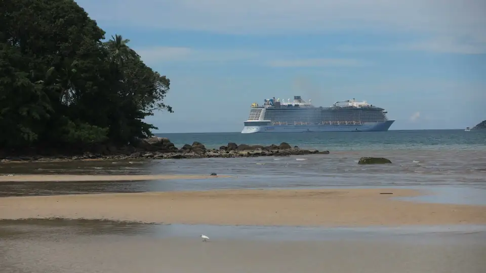 A Royal Caribbean ship anchored off a quiet beach