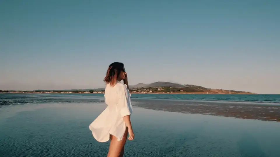 A solo traveler on a calm shoreline