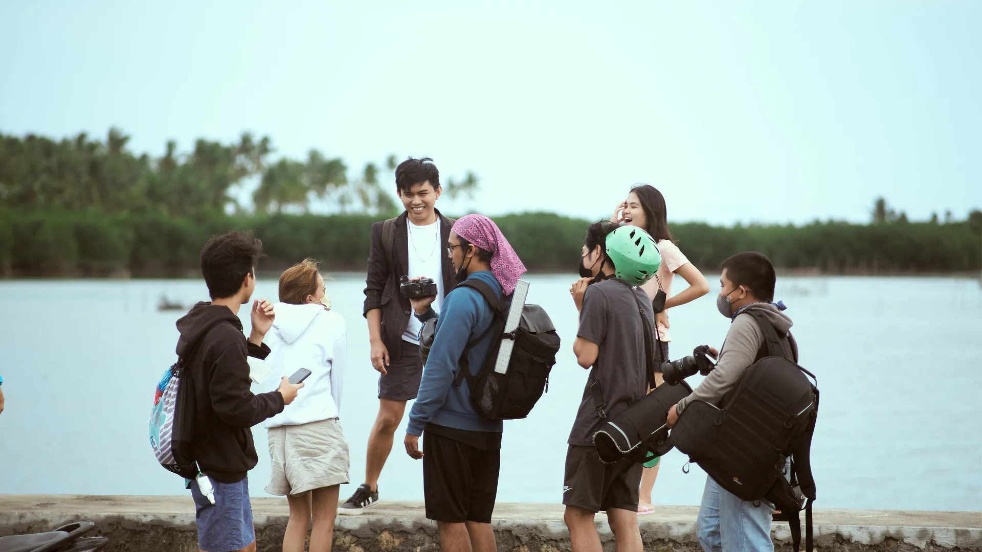 A group of travelers standing together beside a lake