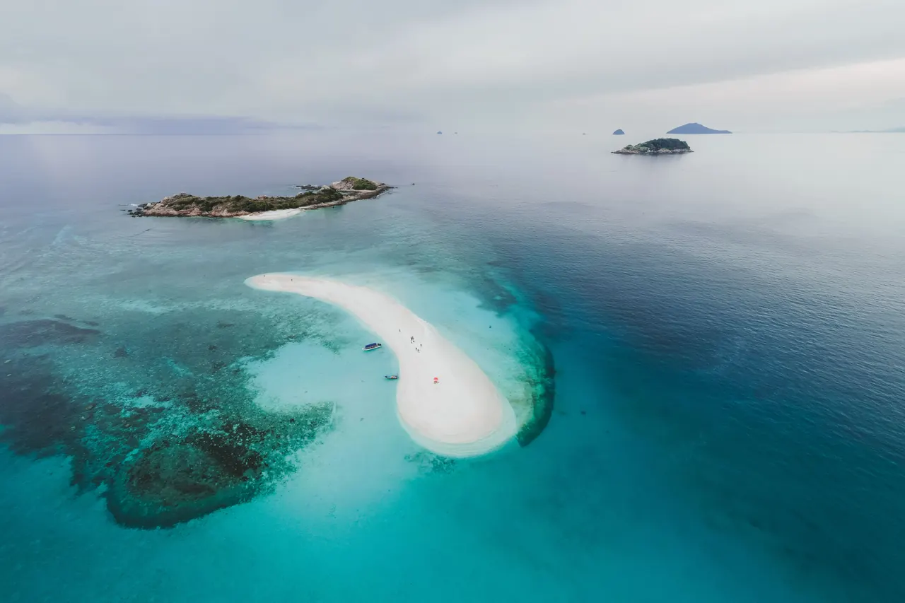 Stunning aerial photo of tropical islands and sandbar with clear blue water.
