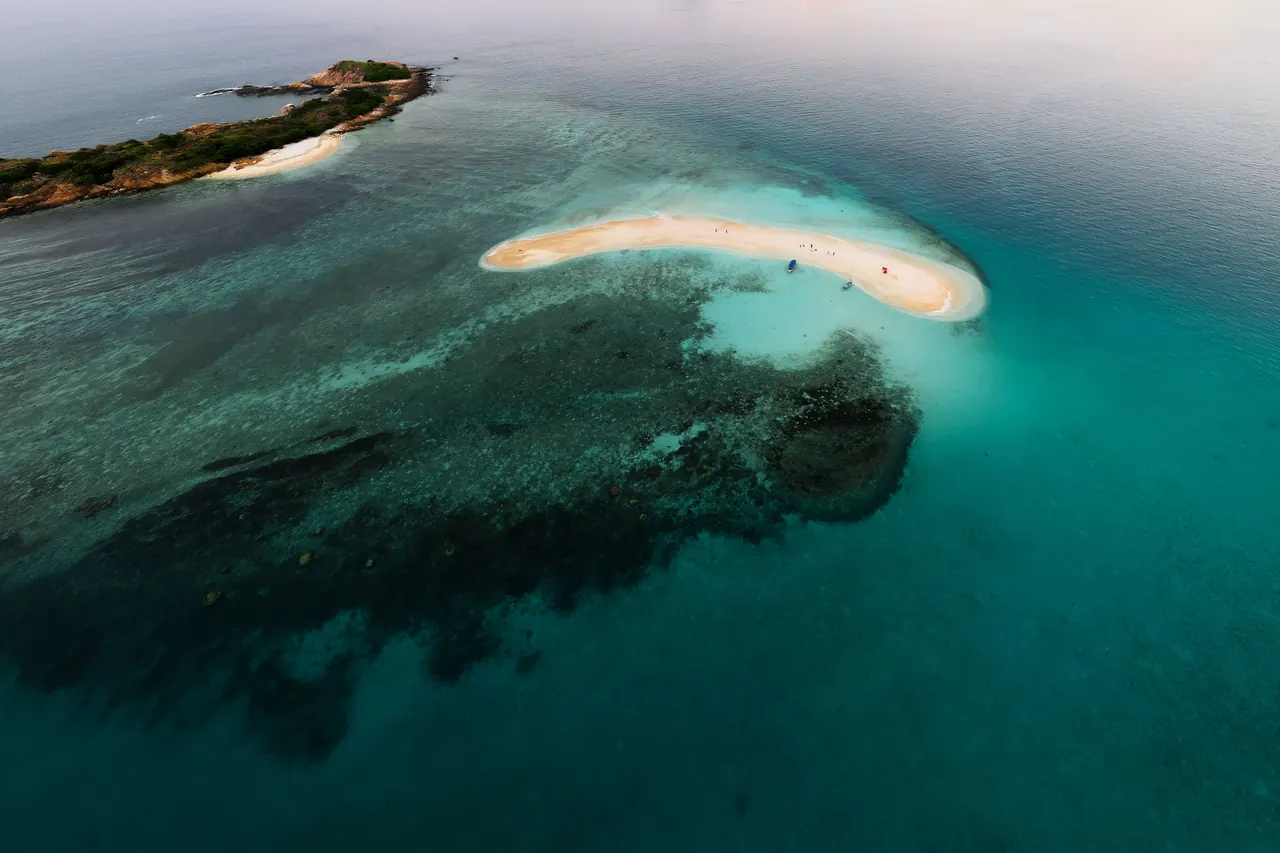 A stunning aerial shot of a secluded tropical island surrounded by turquoise waters, perfect for travel and nature enthusiasts.
