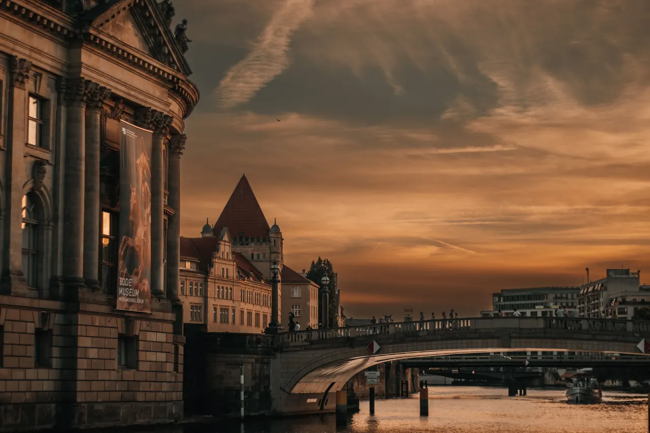 Stunning sunset view of Berlin’s Bode Museum by the river, showcasing architectural beauty.