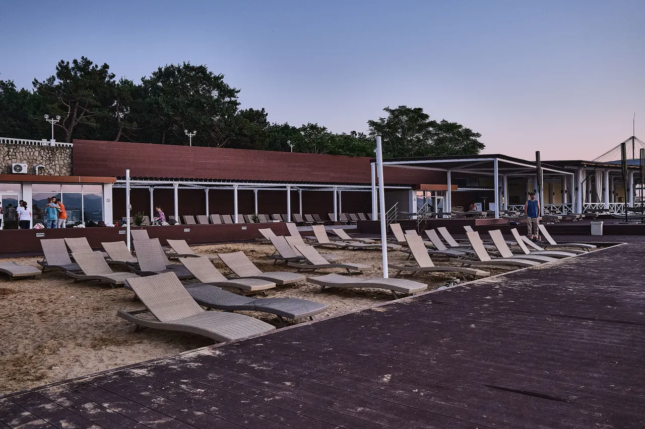 Serene empty beach resort with rattan loungers at twilight, perfect for relaxation.