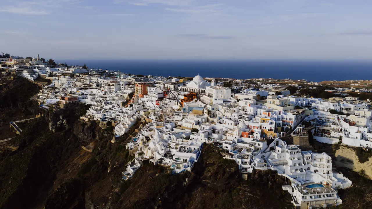 Stunning aerial view of Fira’s iconic white architecture against the Aegean Sea.
