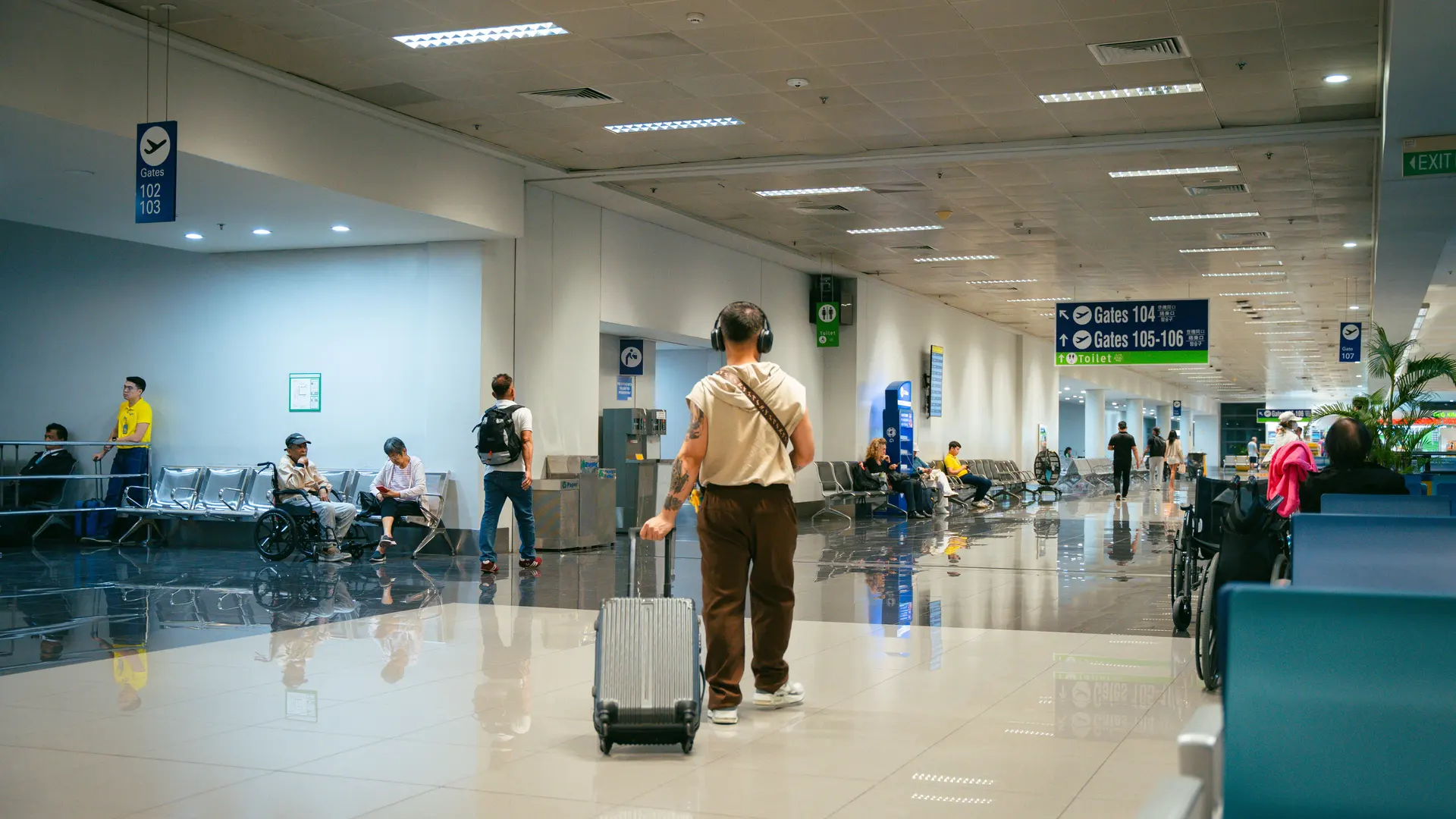 Passengers moving through a bright, spacious airport terminal