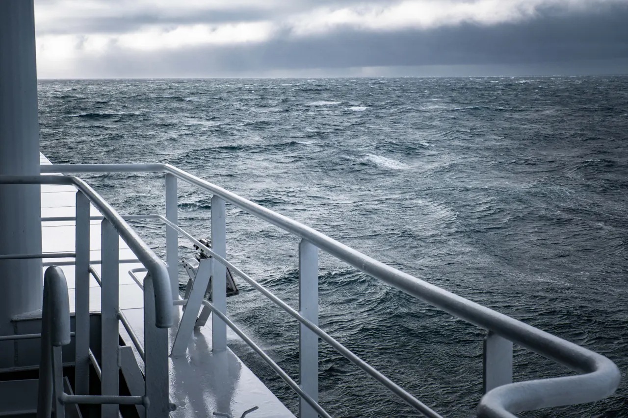 Dramatic sea view during stormy weather from a ship’s deck, showcasing turbulent waters.