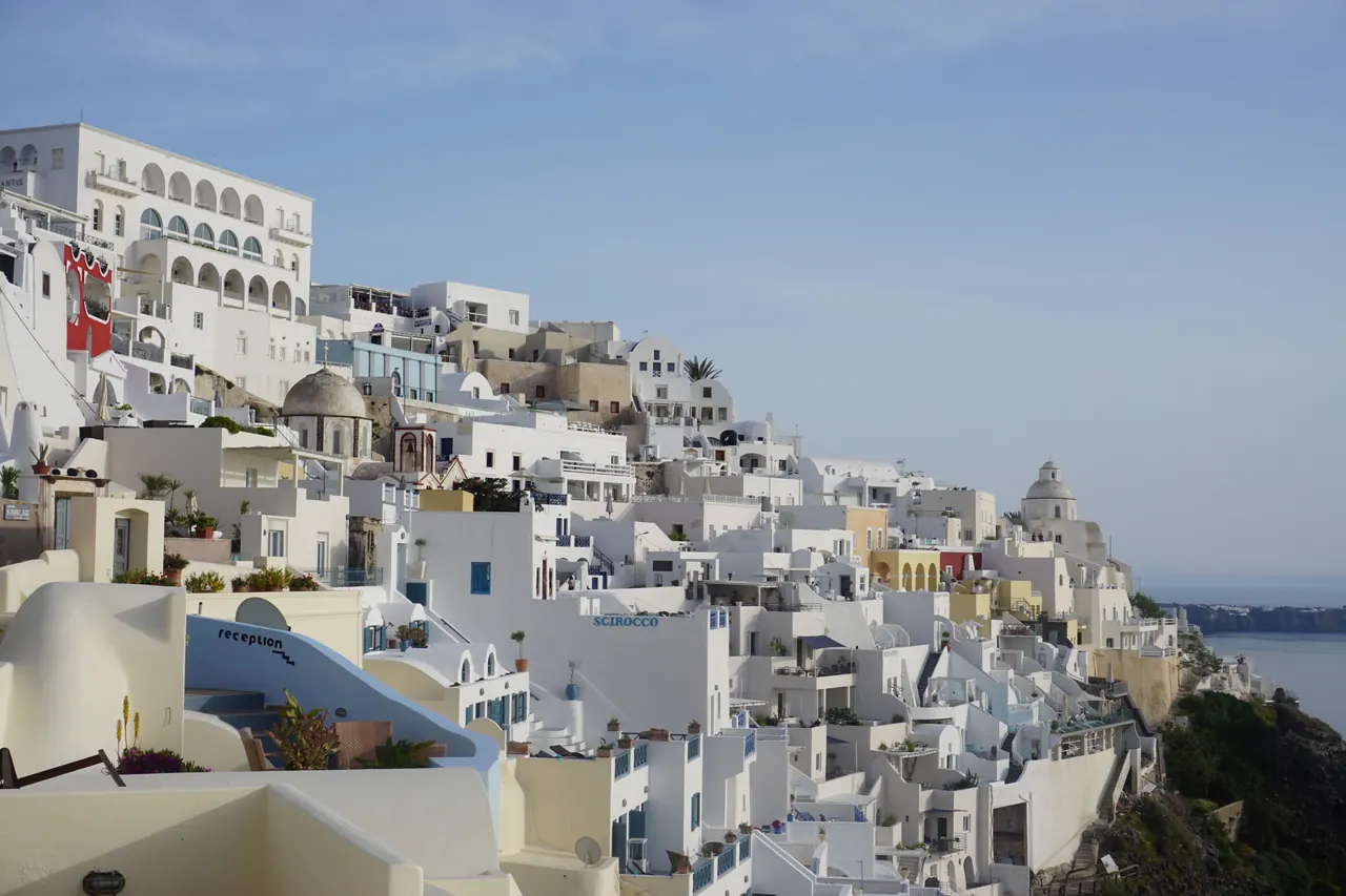 Scenic view of Santorini’s whitewashed buildings and Aegean Sea from Thera, Greece.