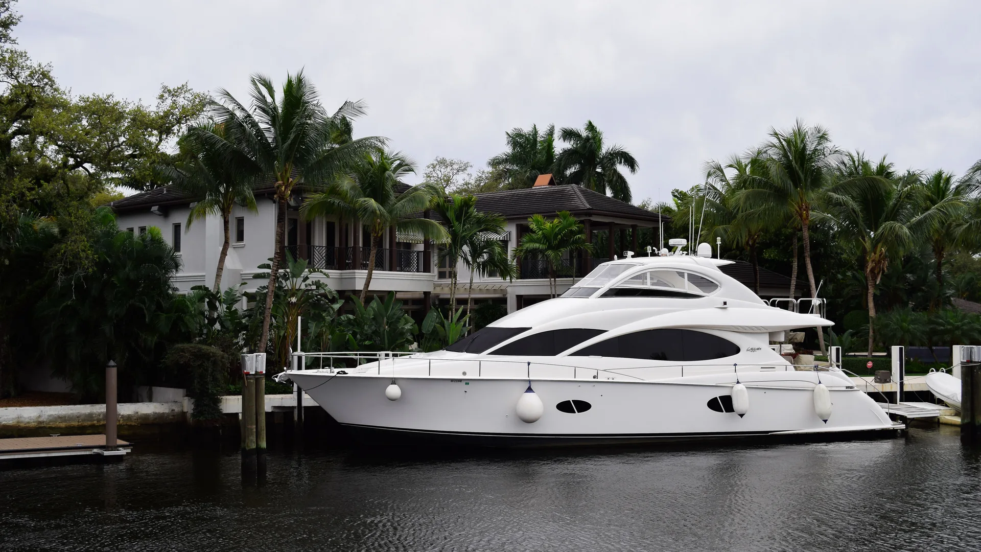 A sleek yacht moored beside palm trees on a Fort Lauderdale waterway
