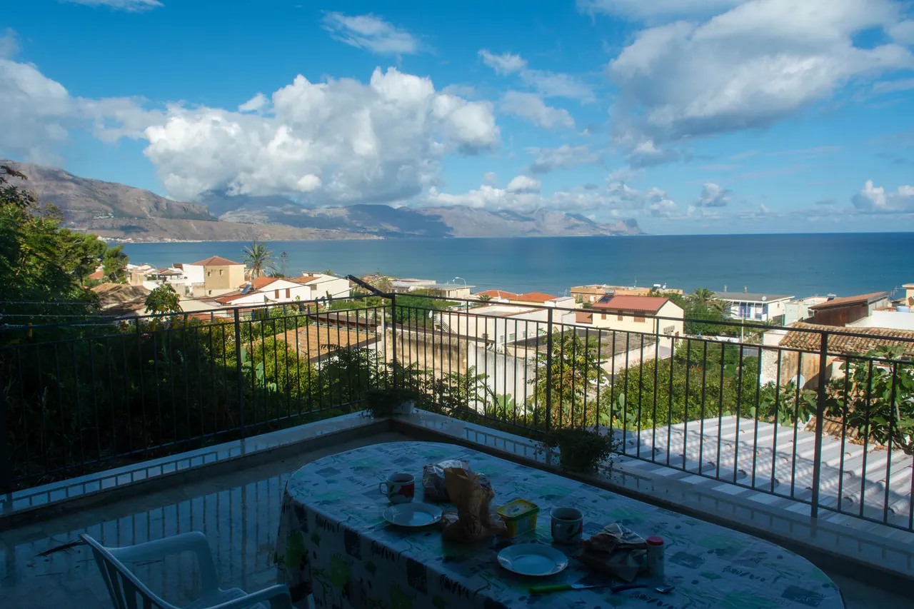 Enjoy a picturesque seaside view from a balcony in Alcamo Marina, Sicily, with a breakfast setting.
