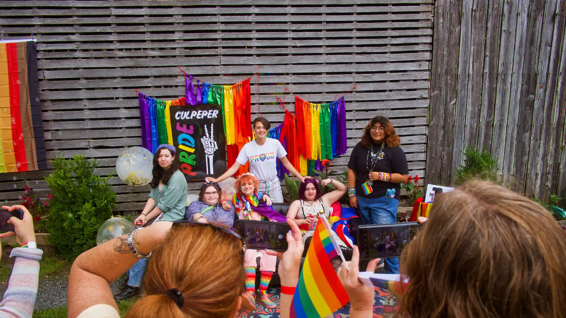A group of people celebrating together holding Pride flags