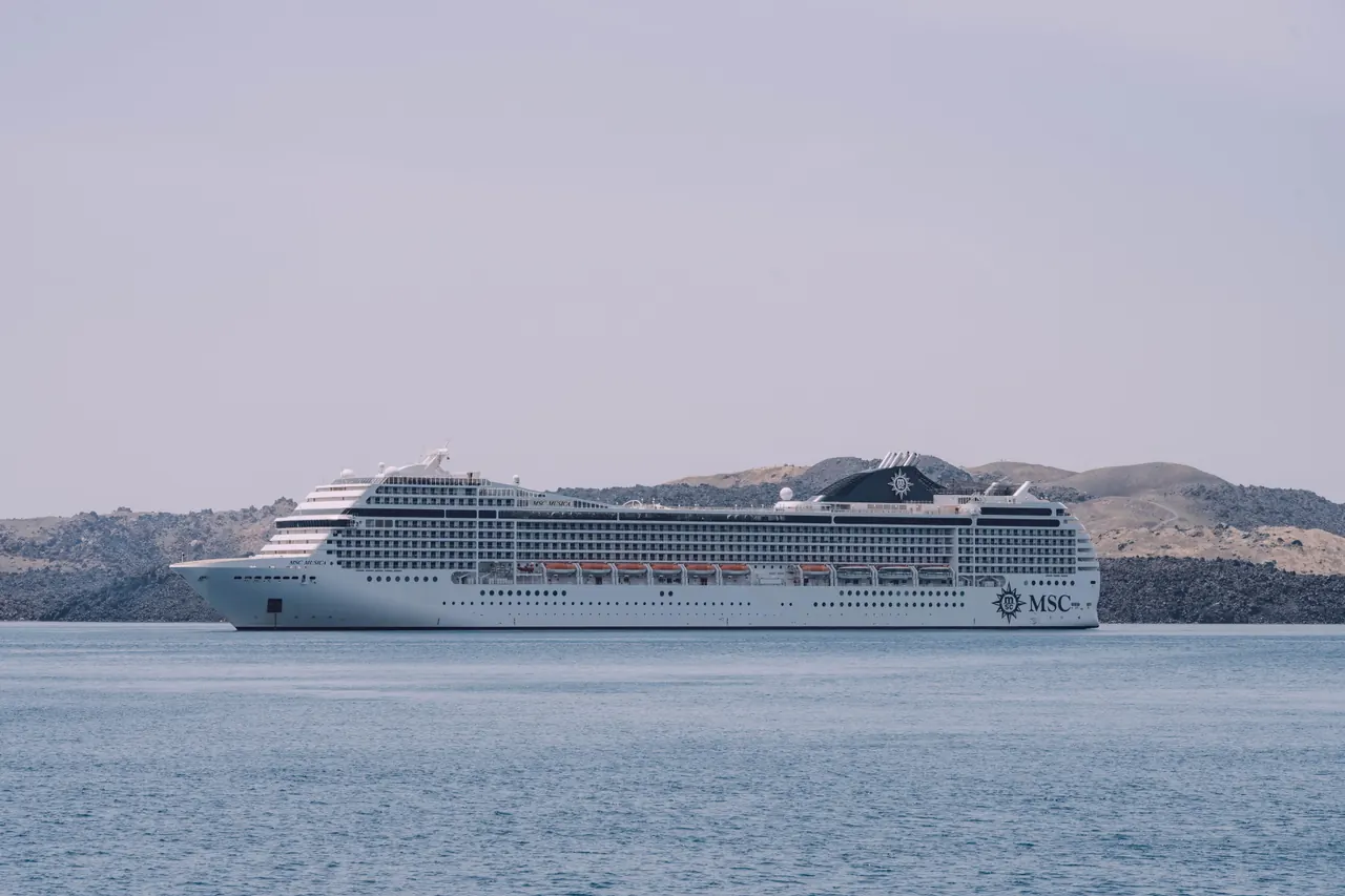 White MSC cruise ship sailing peacefully on the sea against a scenic coastline backdrop.