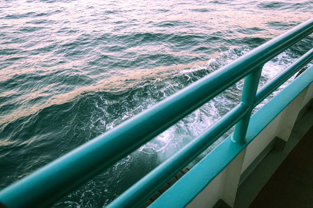 A serene view of ocean waves from a ship’s deck, highlighting tranquility of sea travel.