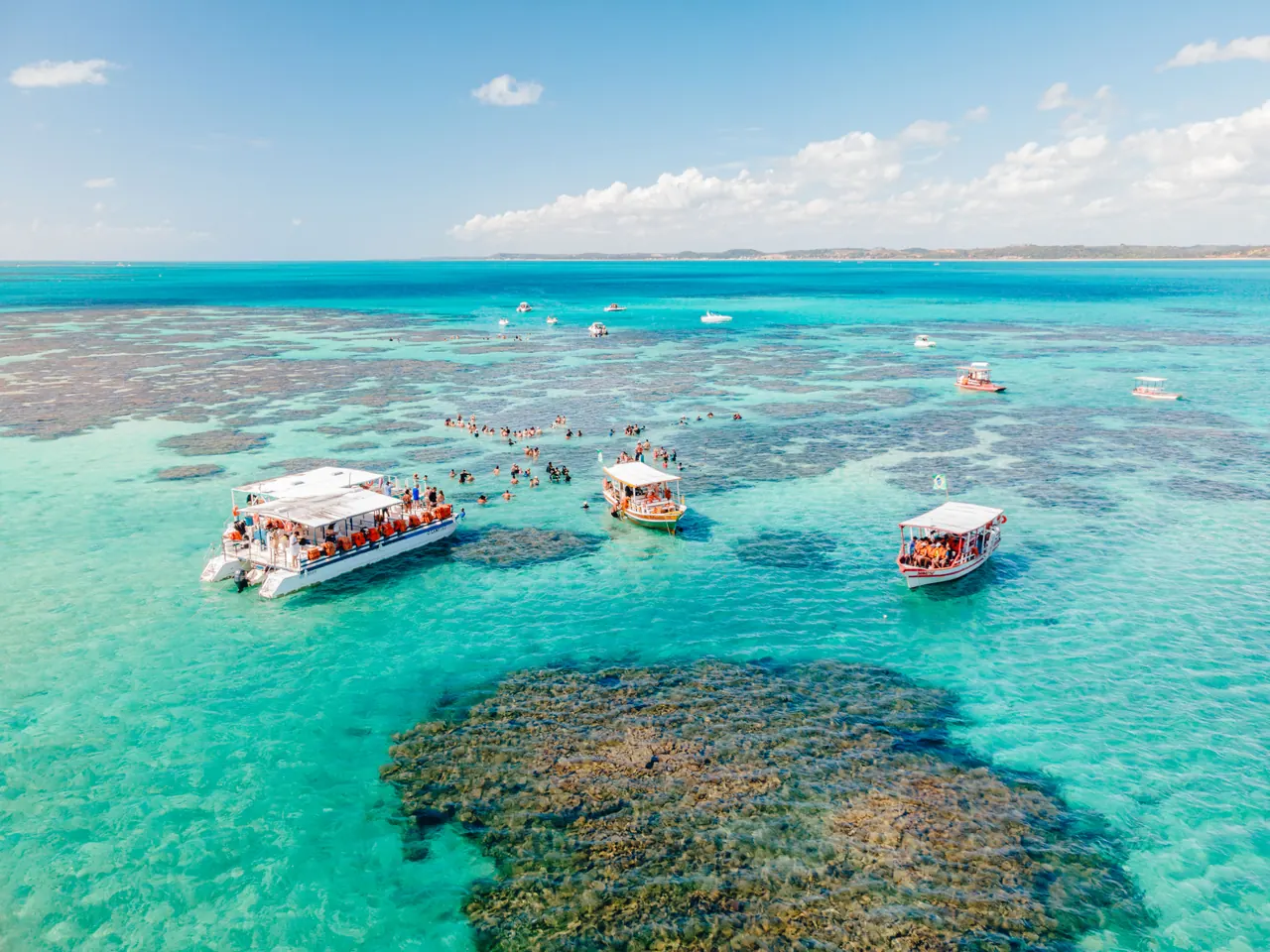 Discover the stunning turquoise tide pools of Maragogi, Brazil, under a clear blue sky.