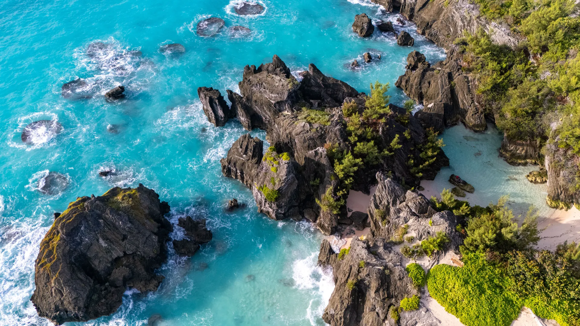 Aerial view of turquoise water breaking on Bermuda’s rocky coastline