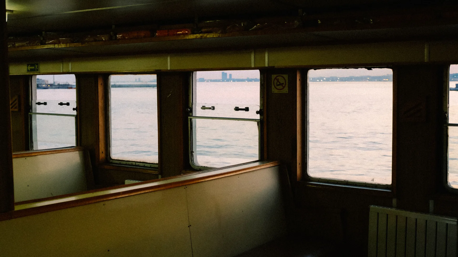 A calm sea horizon viewed through a window from inside a ship