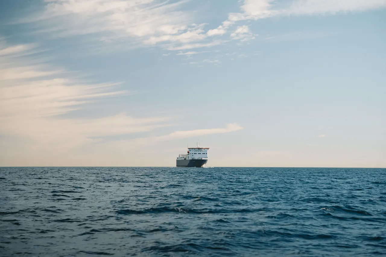 A cargo ship sailing on the calm waters of Baja California Sur, México, under a clear sky.