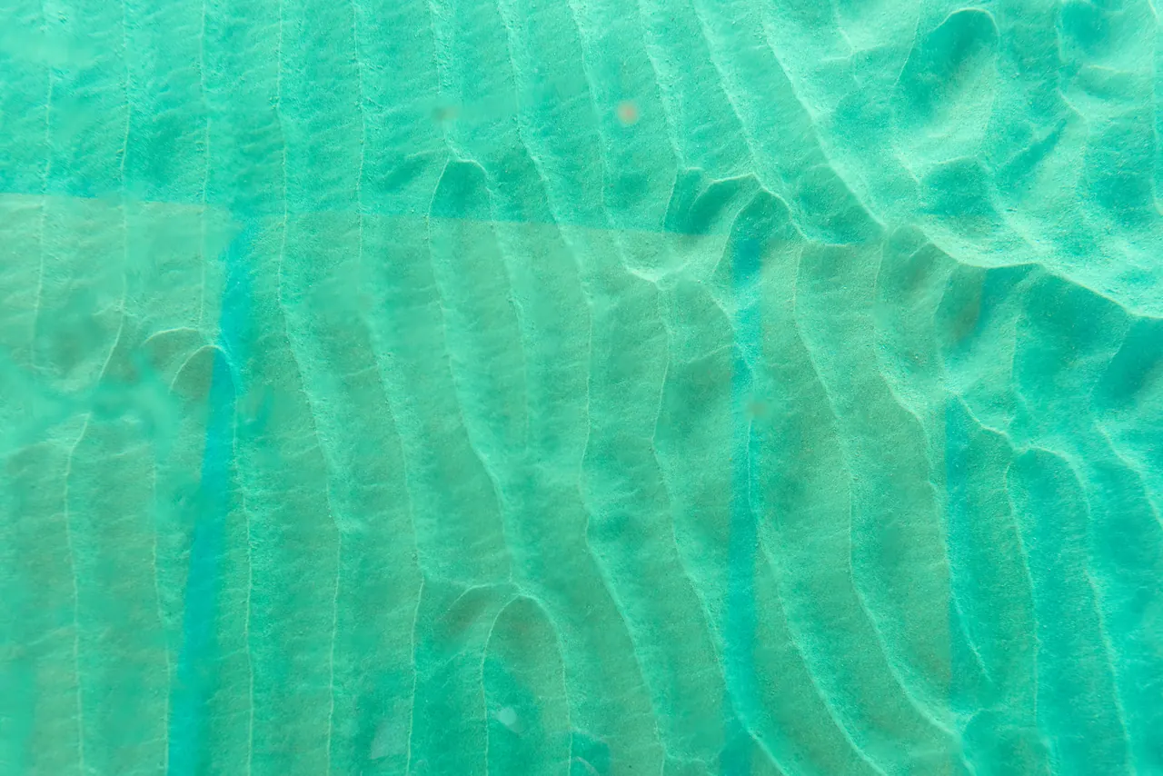 Stunning aerial view of turquoise waters and sandy seabed textures off Tobago’s coast.