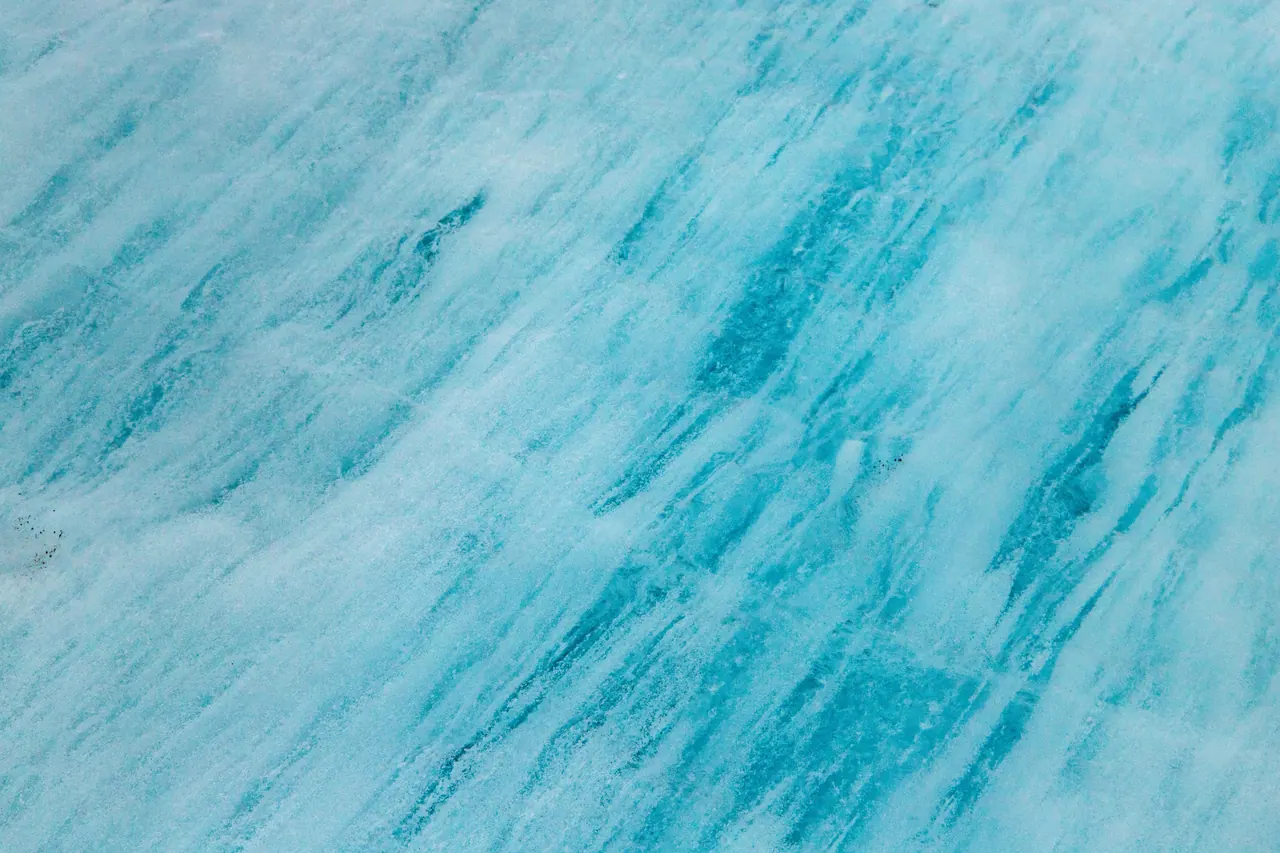 Explore the vibrant turquoise patterns of Iceland’s pristine ice glacier surface.