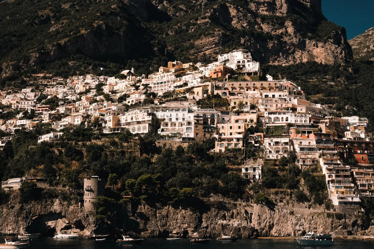 A stunning view of the Amalfi Coast with picturesque buildings perched on steep cliffs.
