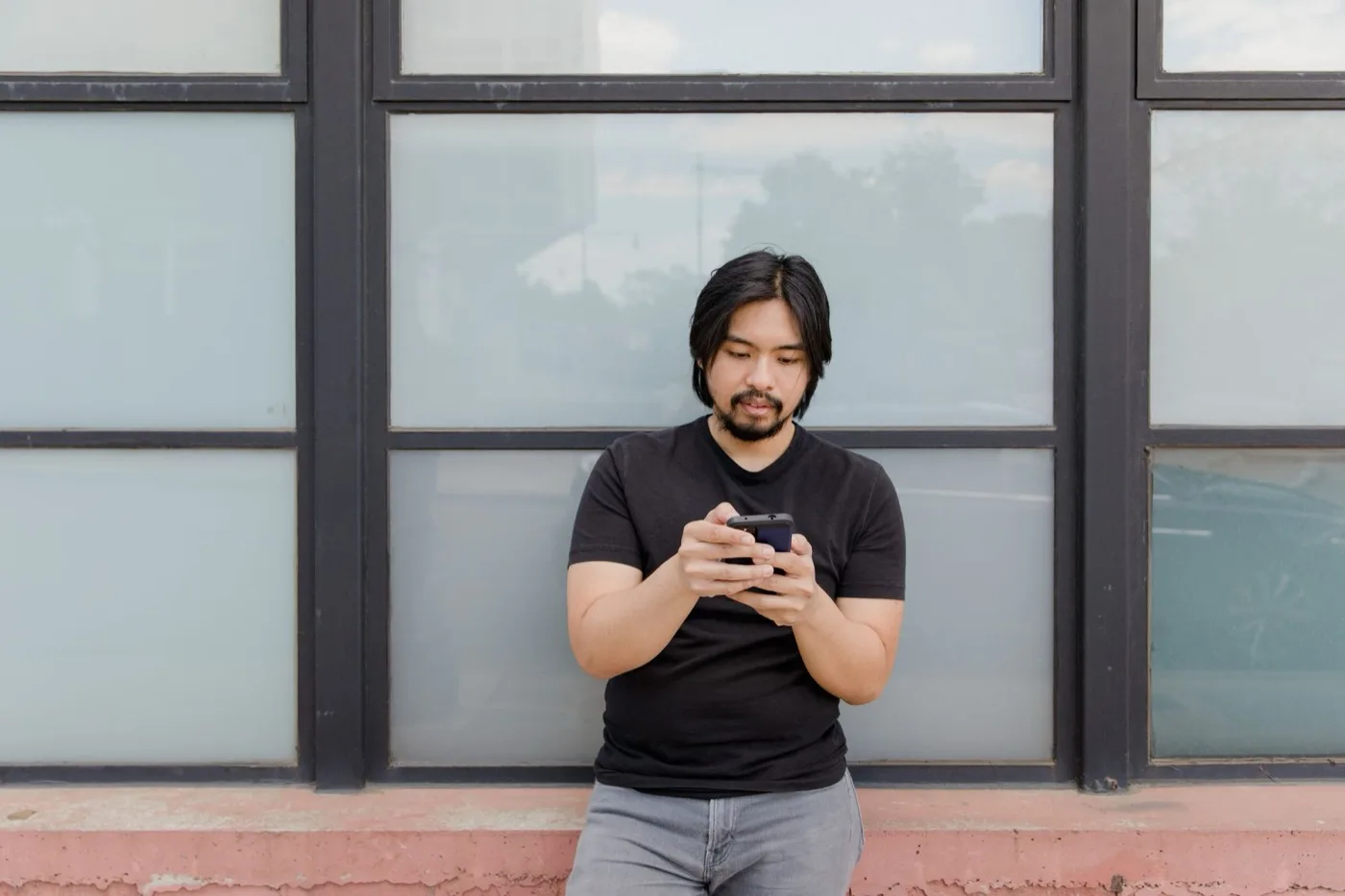 A traveler checking a phone while standing outdoors in an unfamiliar city