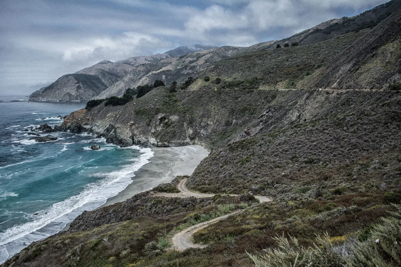 Beautiful coastline with rugged cliffs and a winding path by the ocean.