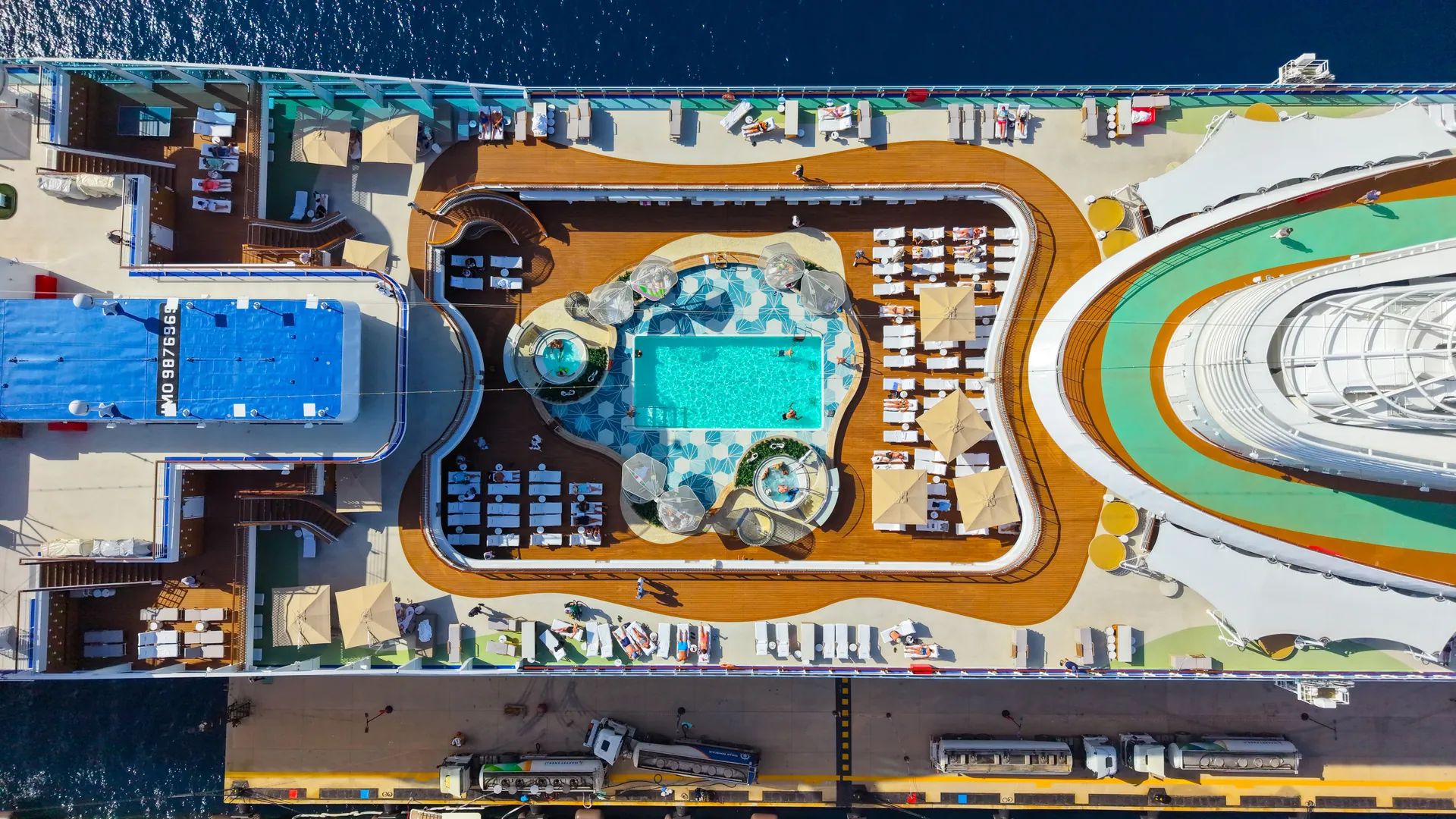 Aerial view of a cruise ship pool deck lined with loungers and umbrellas